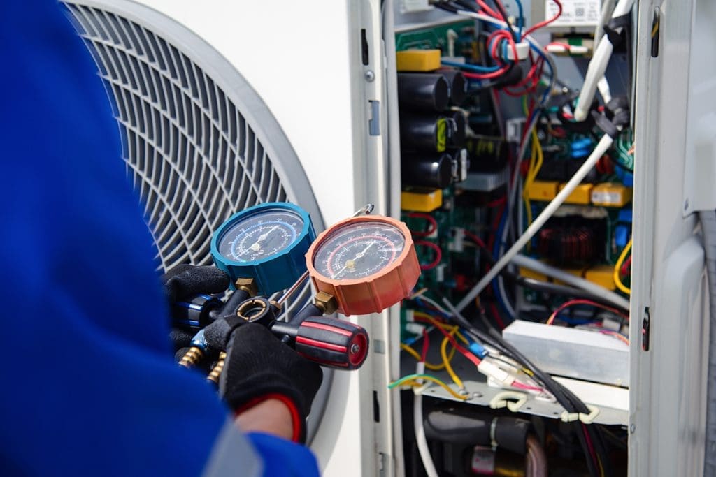 An HVAC technician performing geothermal system maintenance on an indoor unit in York, PA